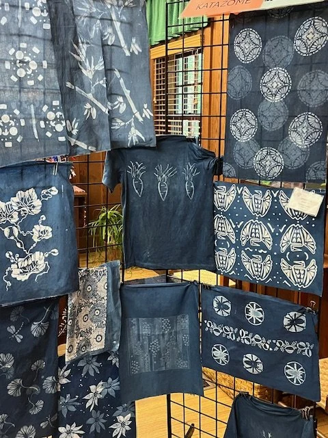 Suzanne's katazome indigo pieces hung on a grid display