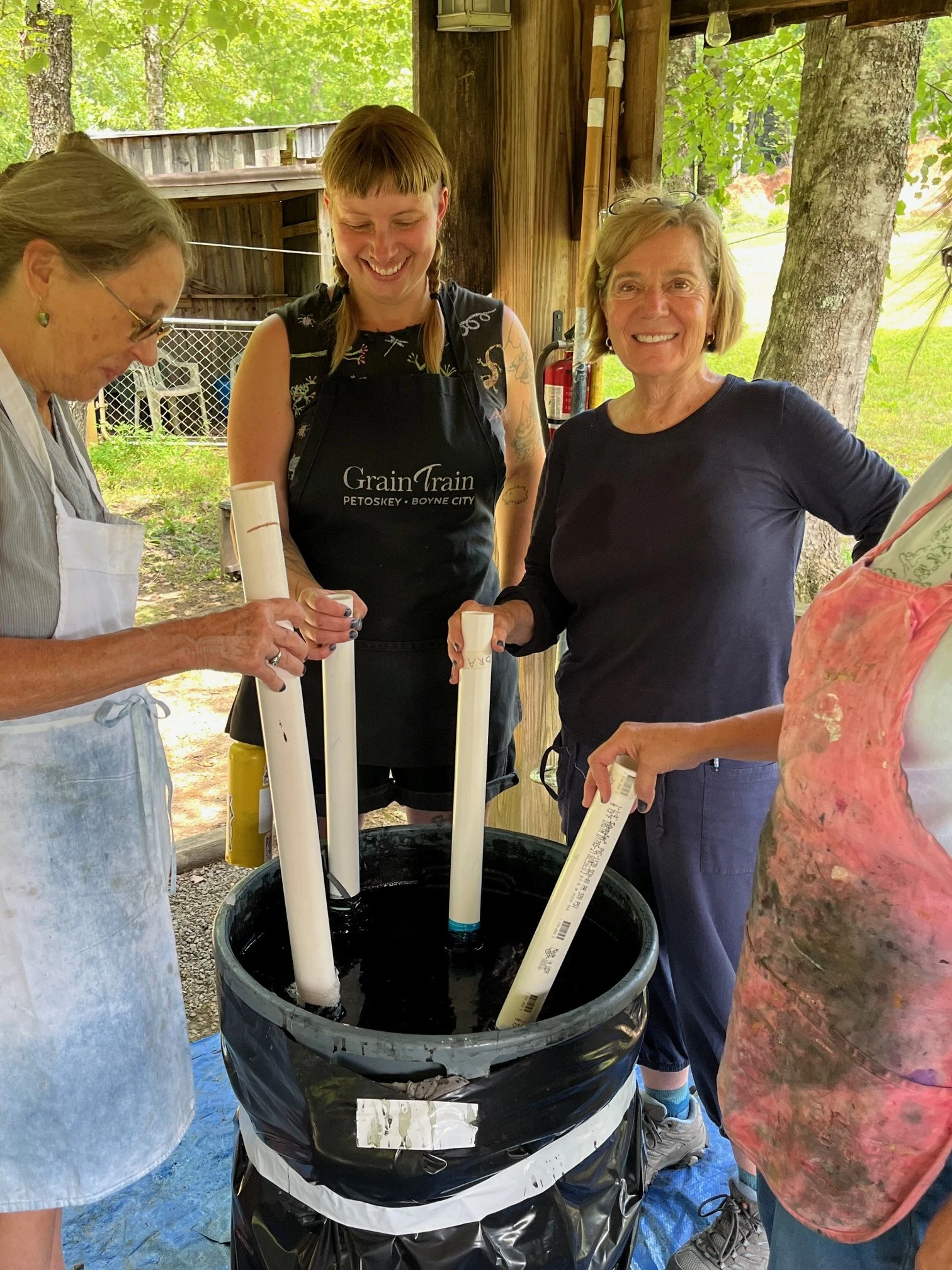 Three women at an indigo dye bucket at Suzanne's North Carolina retreat